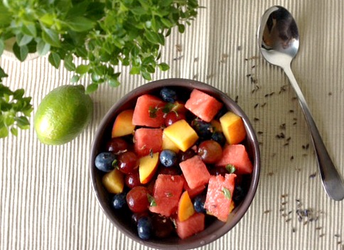 lavender and basil summer fruit salad in bowl with silver spoon
