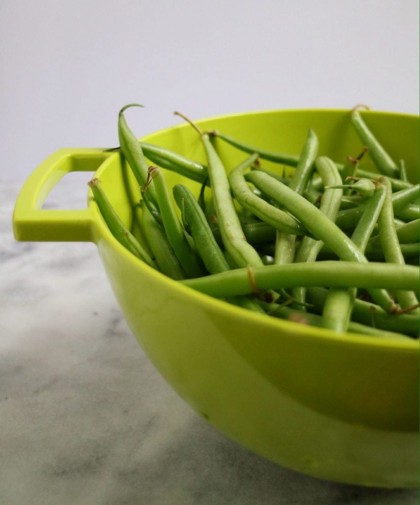 Fresh green beans in a green colander