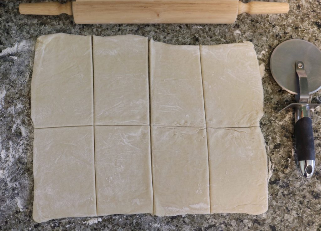 pastry dough rolled out and cut into eight squares with a pizza cutter