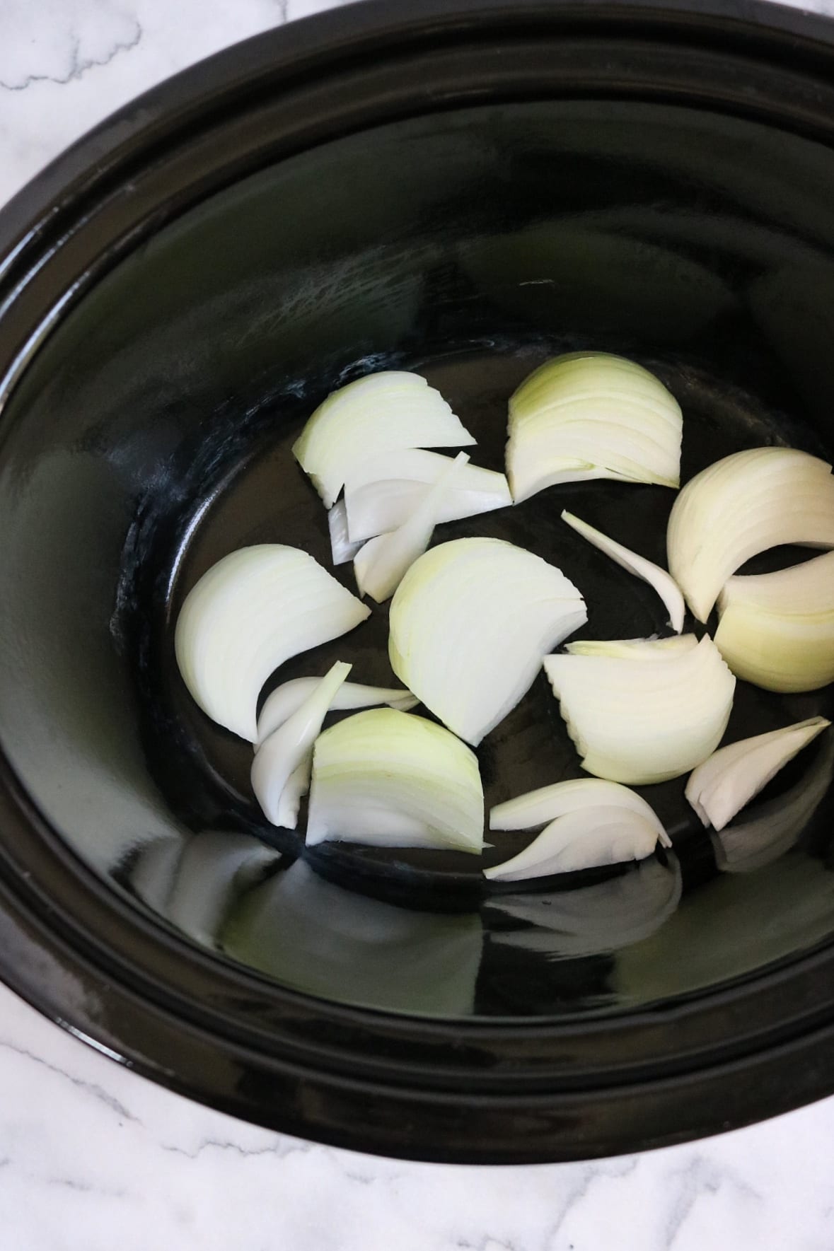 Onions in the base of a slow cooker | The Nutrition Adventure