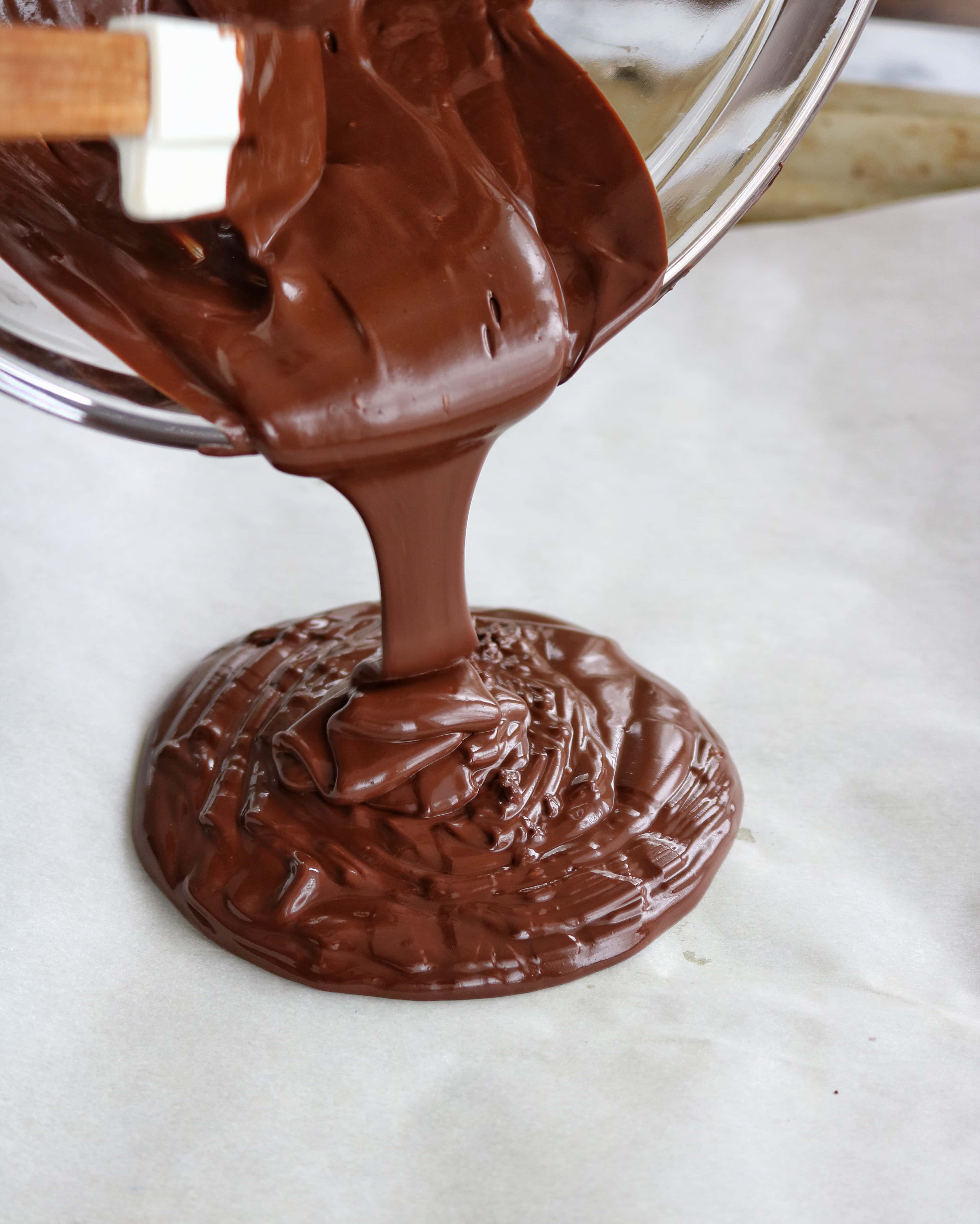 Dark chocolate being poured onto parchment paper | The Nutrition Adventure 