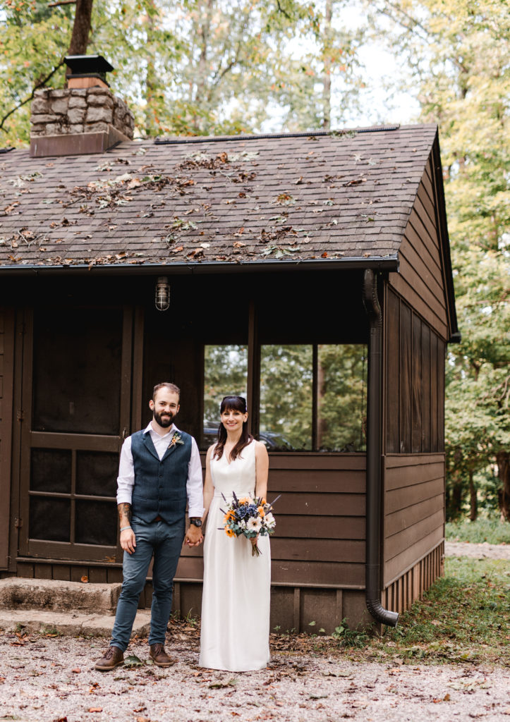 just married couple standing outside cabin at Norris Dam